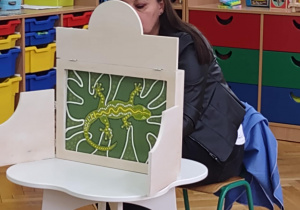 Pani Aneta pokazuje przedszkolakom ilustracje do bajki.